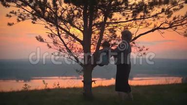 奶奶和孙子在夏日夕阳下玩耍，奶奶帮孙子爬树